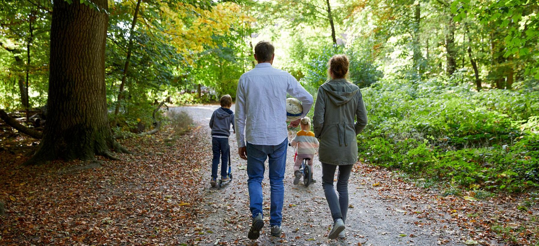Eine Familie spaziert im Wald