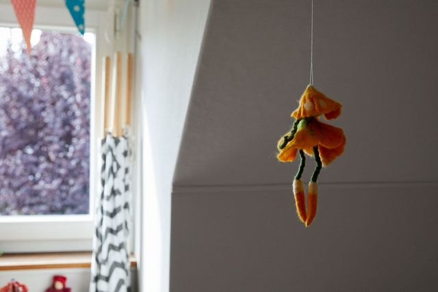 Eine Filzfigur hängt von der Decke eines Kinderzimmers
