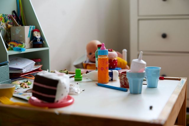 Ein Kinderzimmer mit Tisch, Spielzeug und Bastelmaterial